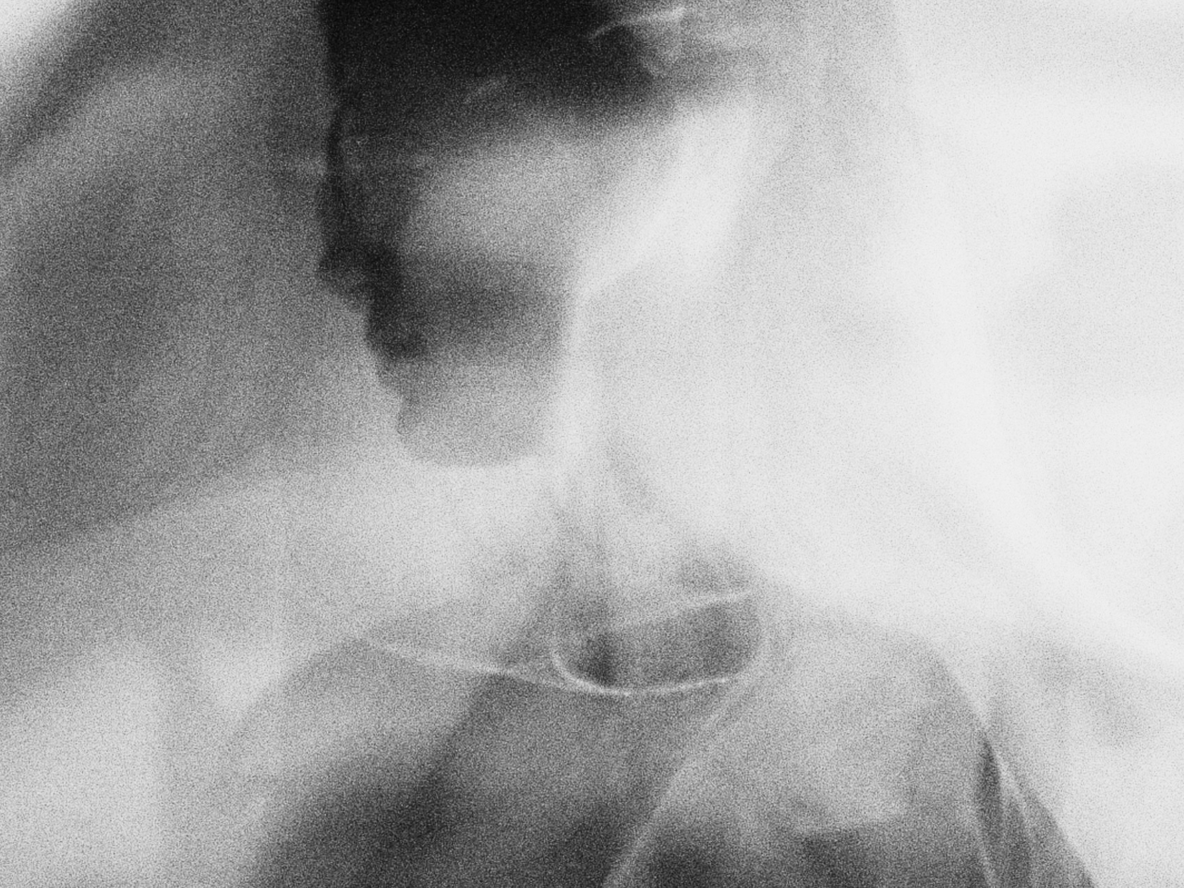 Close up black and white portrait showing one eye and a contemplative expression — representing the art of reading buyer signals and nervous system responses in sales conversations.