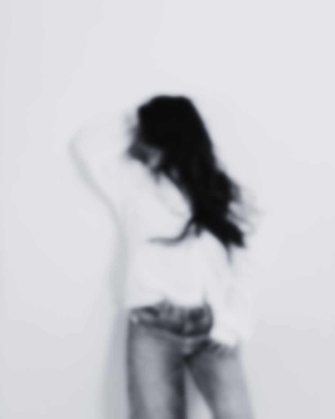 Blurred black and white image of a person standing against a plain wall — representing the invisible emotional experience buyers have inside online business environments.