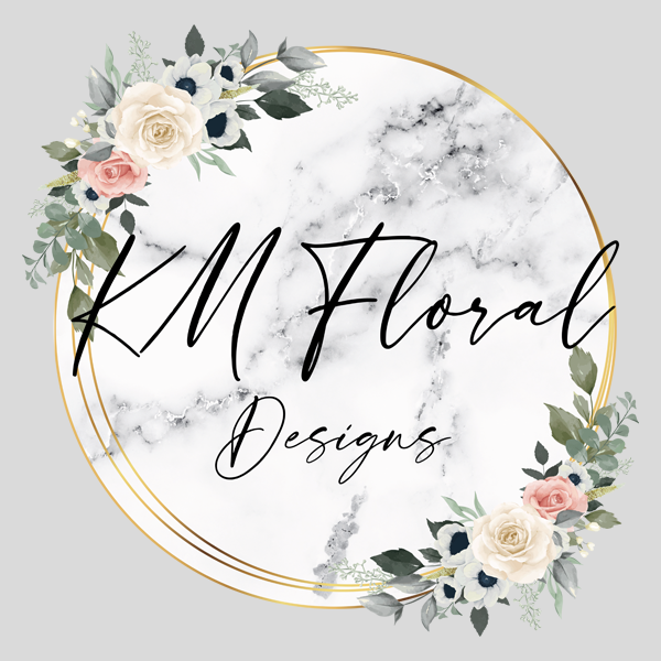 A circular logo with gold borders, featuring a marble background and floral arrangements of white, pink, and dark blue flowers with green and gray leaves, and the text 'KM Floral Designs' in elegant black script.