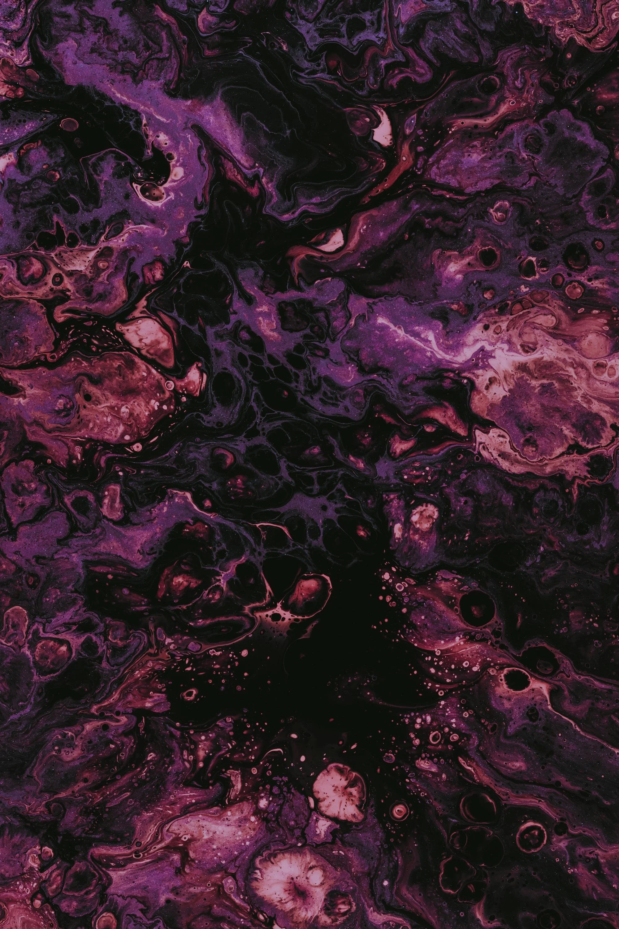 Abstract swirling pattern of purple, pink, and black colors resembling a cosmic or fluid art design.