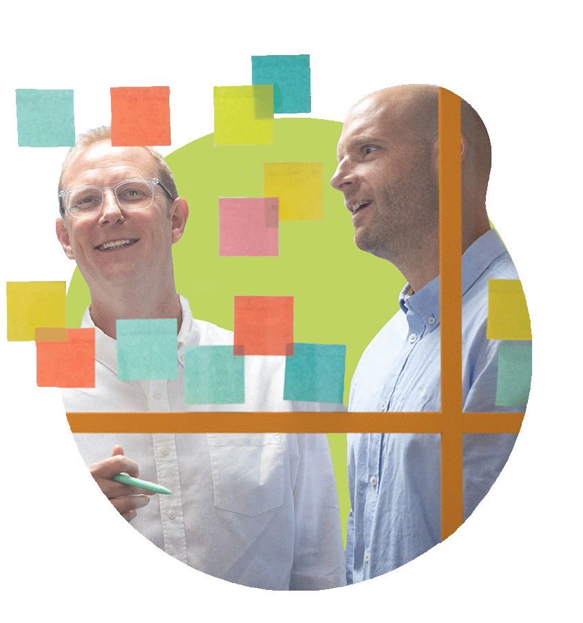 Two men discussing ideas with colourful sticky notes on a glass board