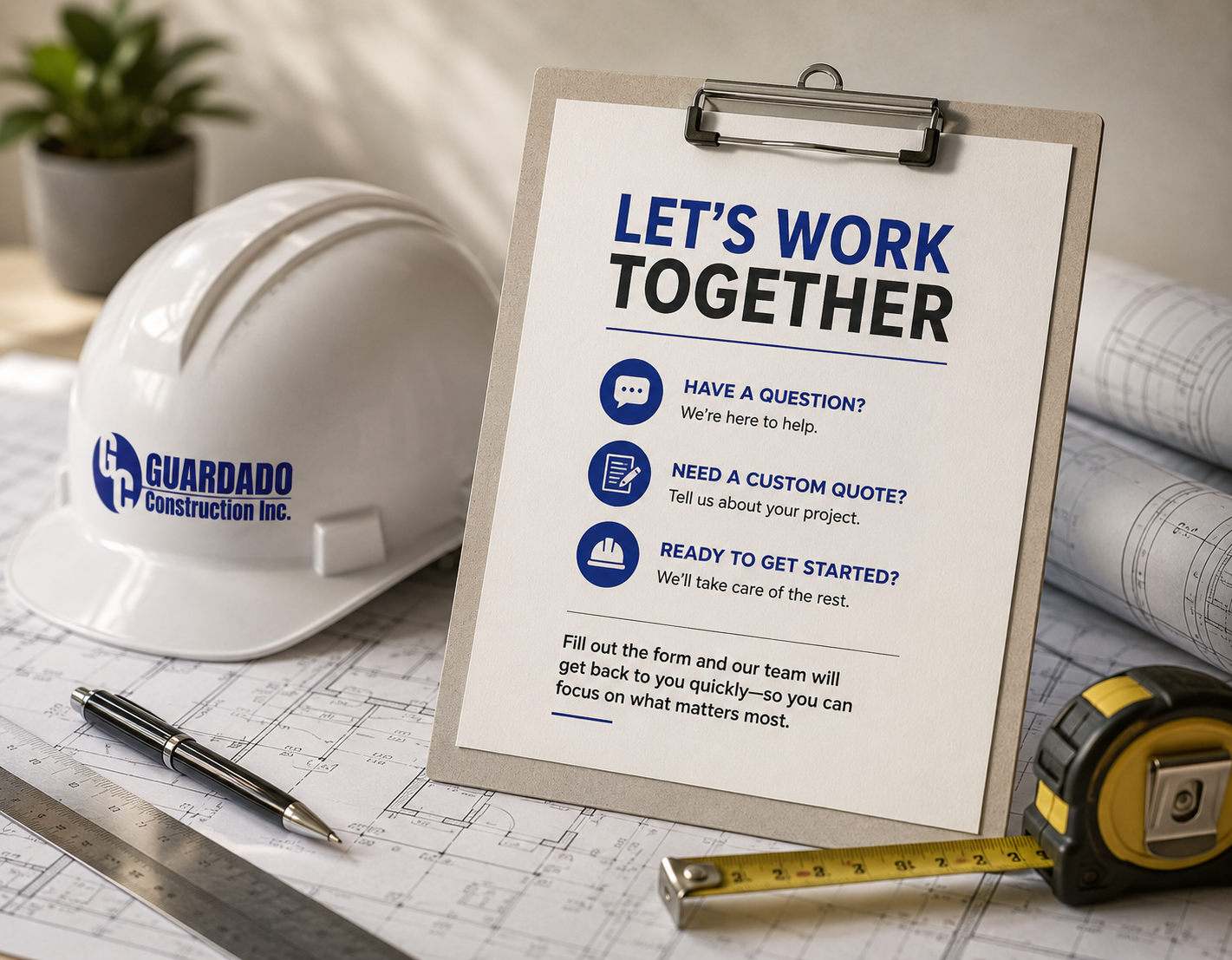 Construction site desk with a white safety helmet bearing a GUARDADO Construction Inc. logo, blueprints, a pen, tape measure, and a sign that reads 'Let's Work Together' with services listed including asking questions, custom quotes, and starting projects.