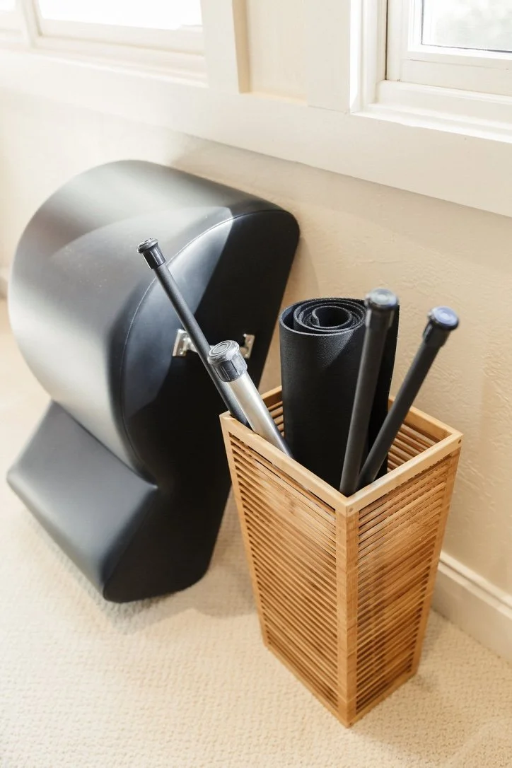 A spine corrector and a basket of pilates props.