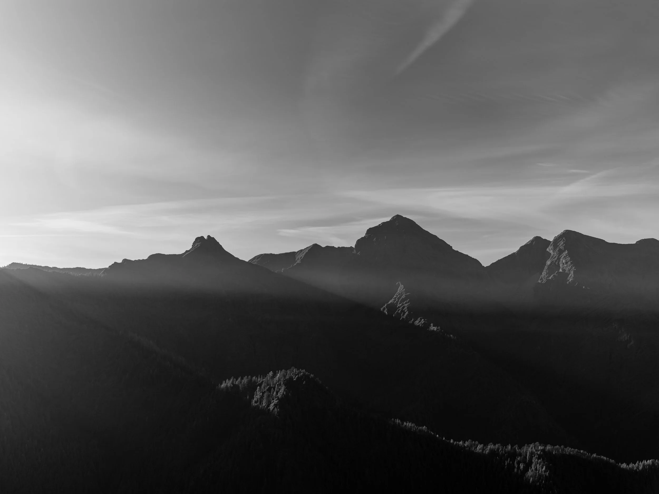 Bergkette mit Wolken und Himmel in Schwarz-Weiß.