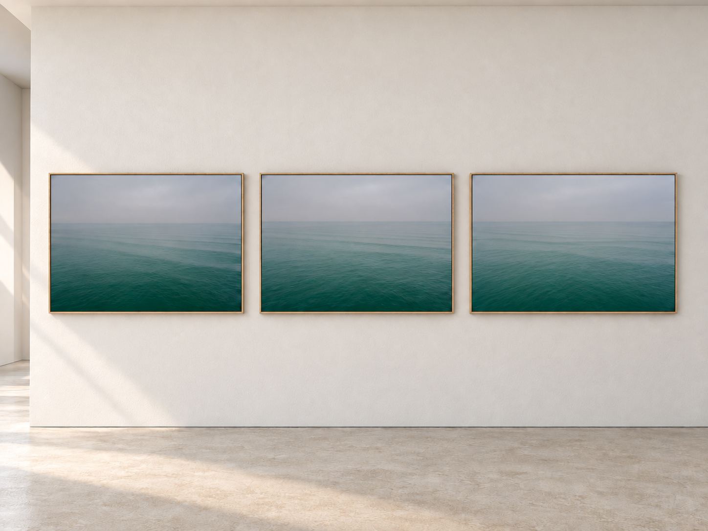 Raumvisualisierung mit drei gerahmten Meeresfotografien an einer weißen Wand.