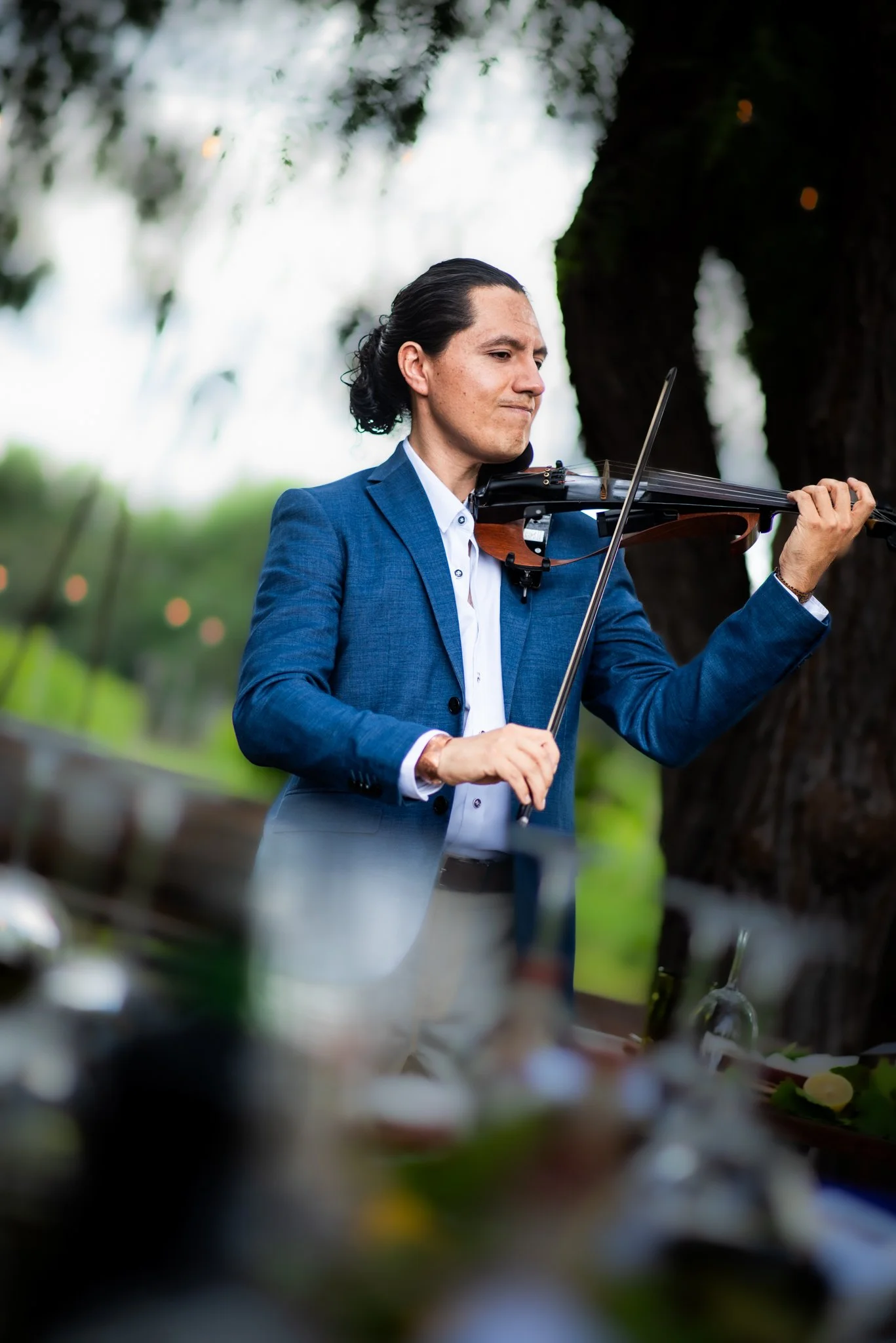 Miguel Fajardo, violinista para bodas, tocando durante una celebración al aire libre en Viña Cordelia, San Luis Potosí.