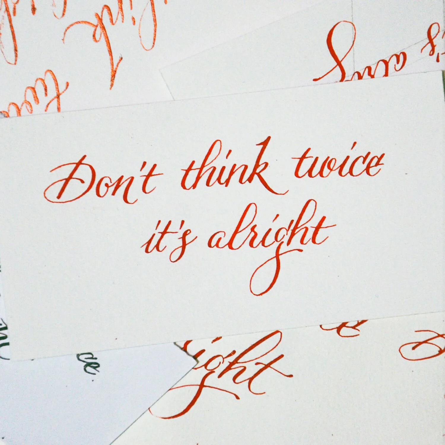 A white card with red cursive handwriting that says, "Don't think twice, it's alright."