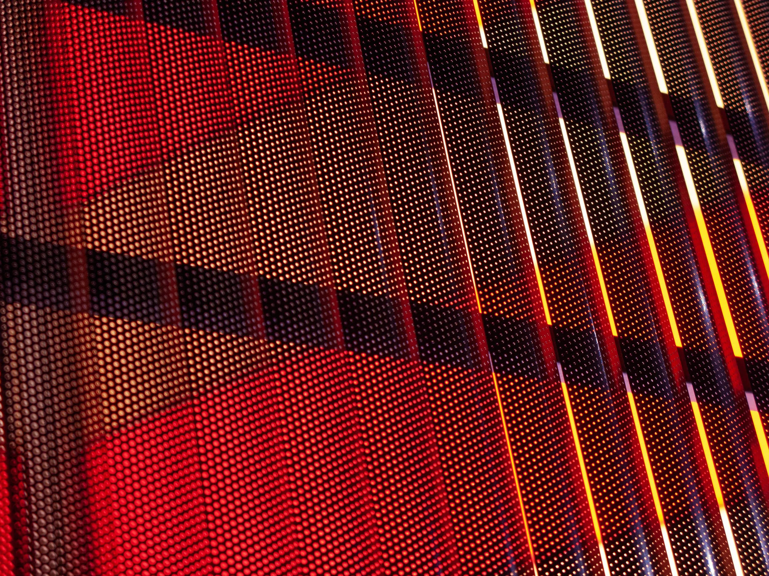 Close-up of a red digital LED display with vertical and horizontal lines and a pattern of small round LEDs.