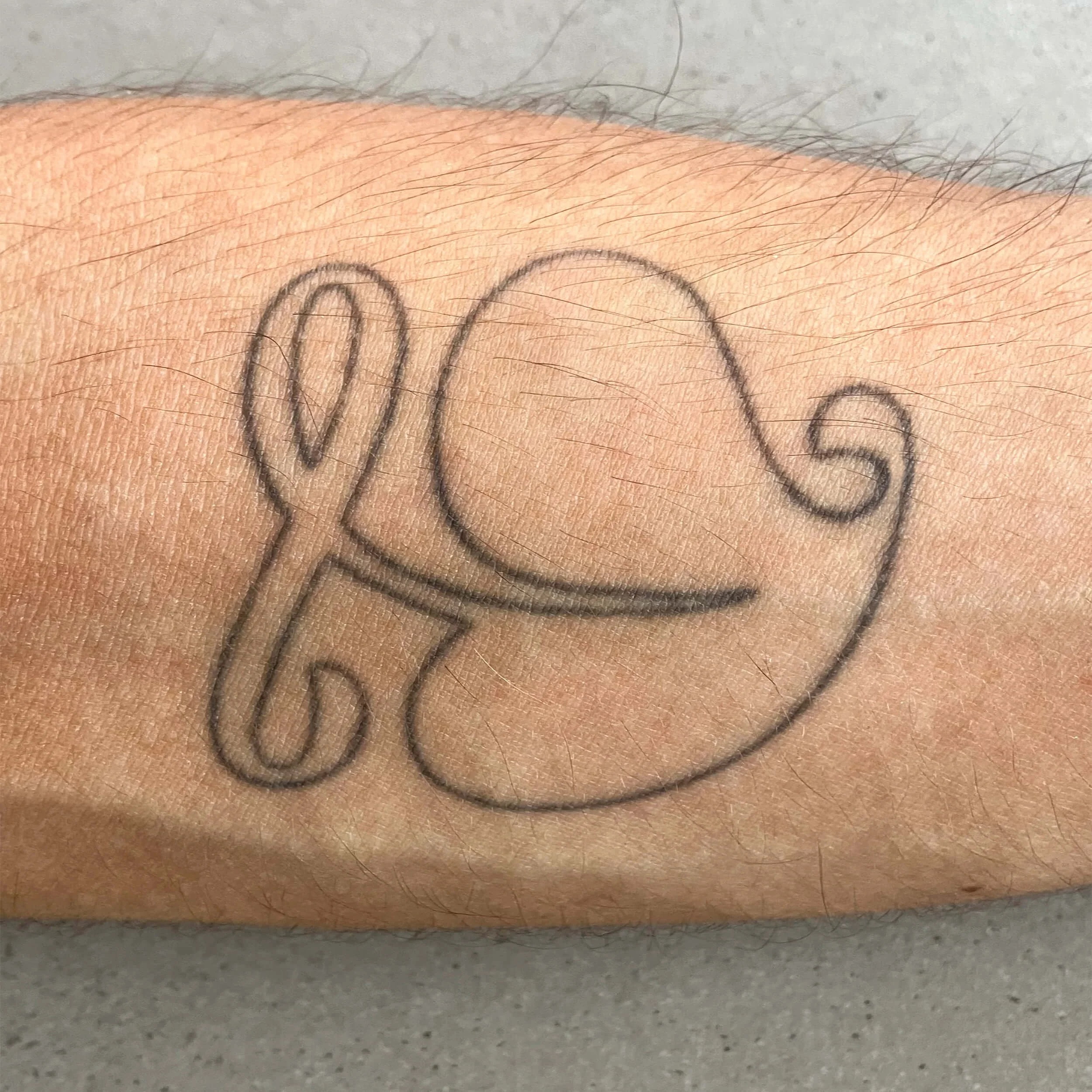 Close-up of a tattoo on a person's skin with the word 'MOM' written in black ink.