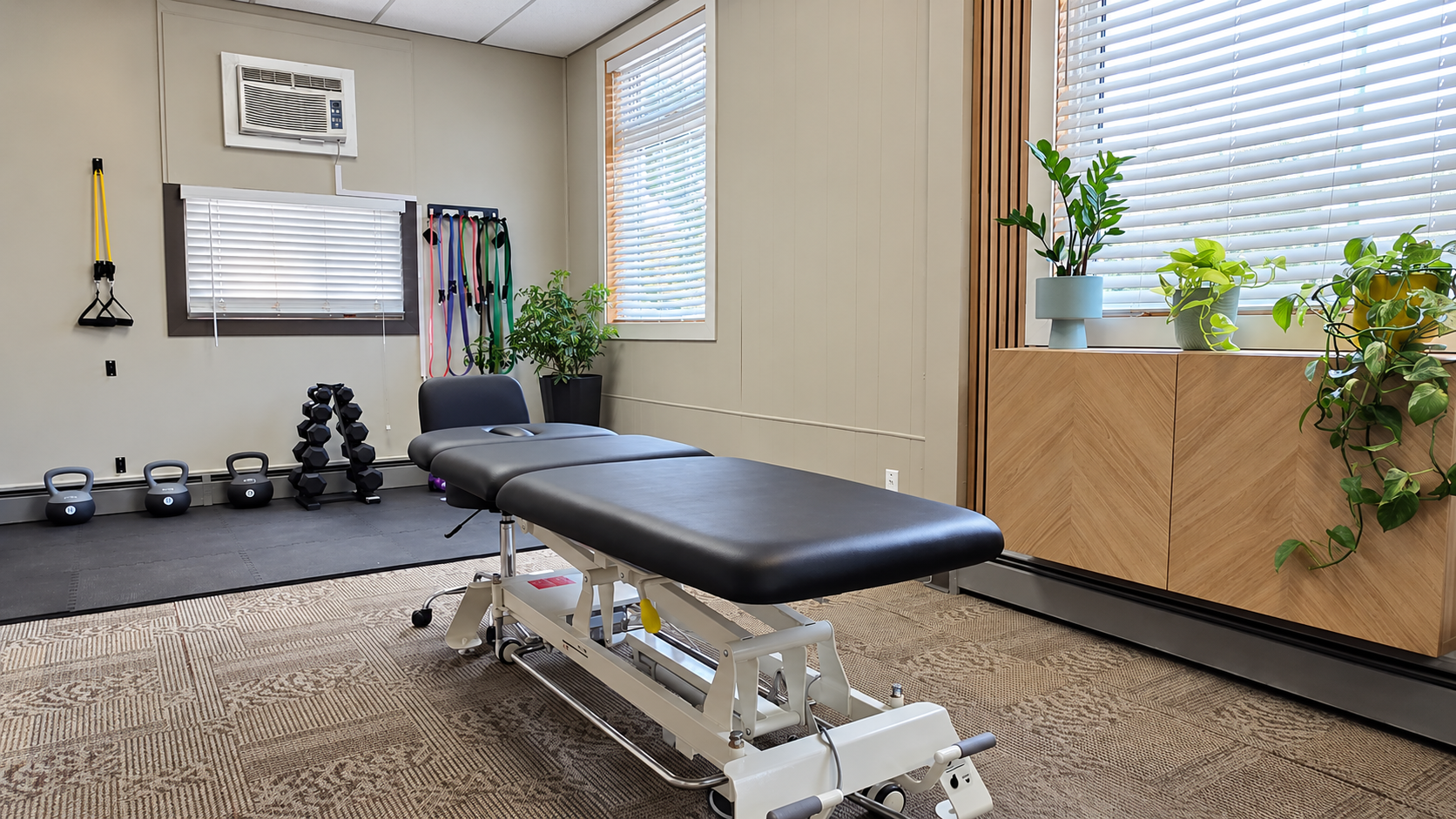 Private treatment room at Northstar Physiotherapy in Cambrian Heights, NW Calgary, with a treatment table and exercise equipment.