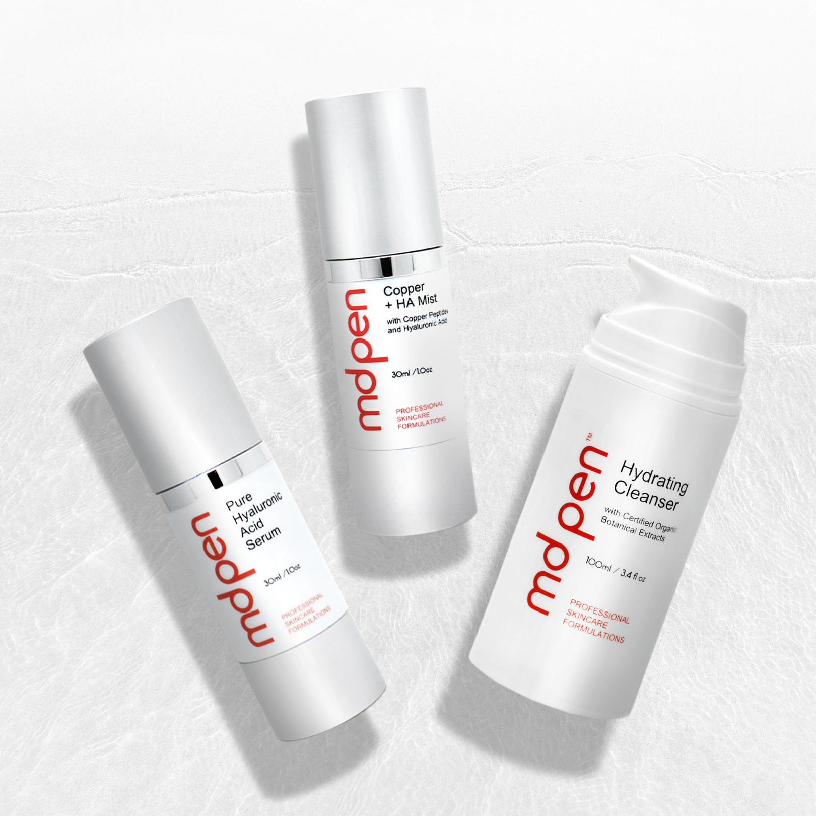 Three white skincare bottles with red and black text on a white textured background.