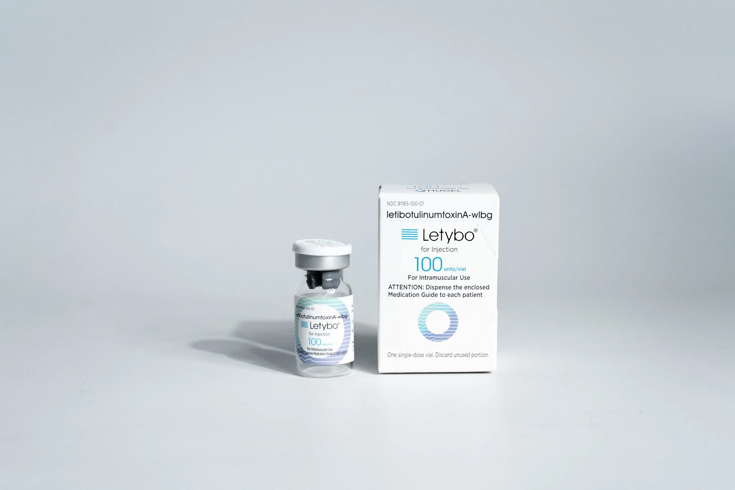 Medical vial labeled Letybo, a box labeled Letibotulinumtoxina-wlbg for injection, and a small vial container, set against a plain light gray background.