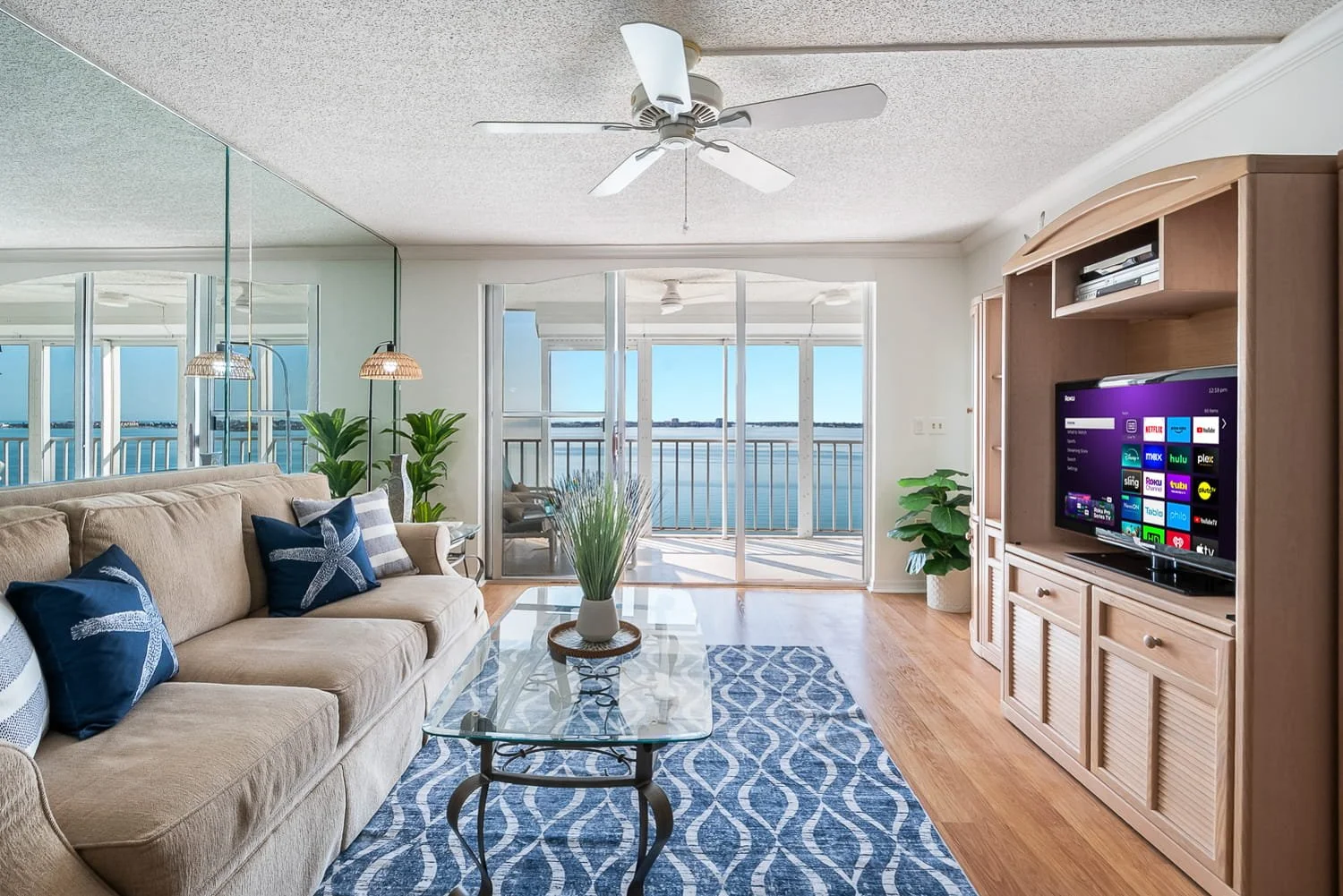 Pinellas County Real Estate Photogaph. Interior condo living room. Cream colored walls, ocean blue rug, and sliding glass doors looking out onto the water.