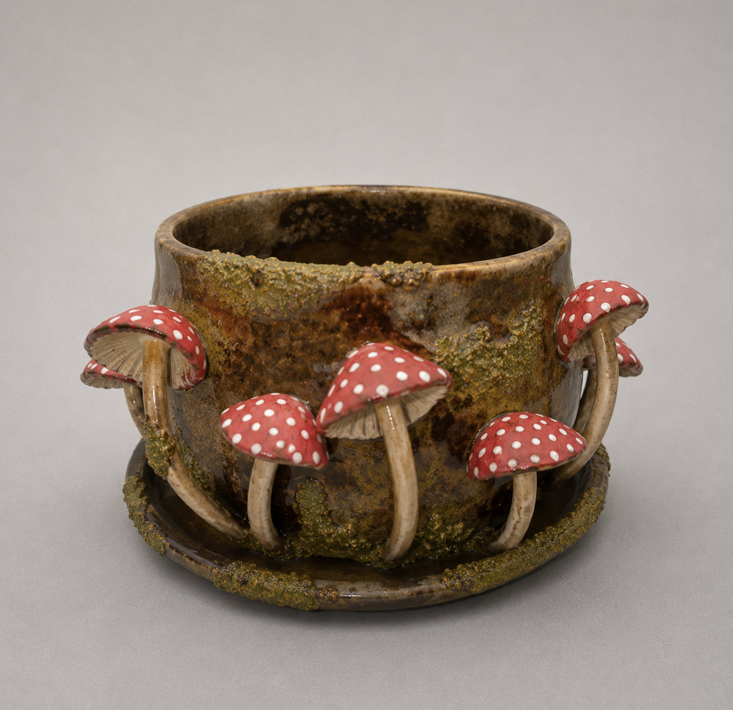 Decorative ceramic pot with red and white polka dot mushroom ornaments attached around its exterior, designed for decorative or ornamental use.