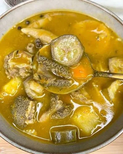 A traditional Jamaican Mannish Water soup with goat meat, root vegetables, and dumplings