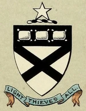 A black and white embroidered shield with three stars at the top, three small squares beneath them, a large white triangle, and a crossed pattern below. A blue ribbon at the bottom reads "Light Thieves All" with two small orange figures on each end.