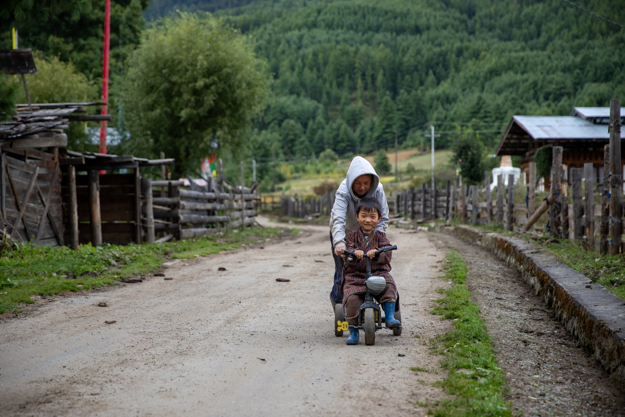 Chumey Valley, Bhutan kids ride a bike