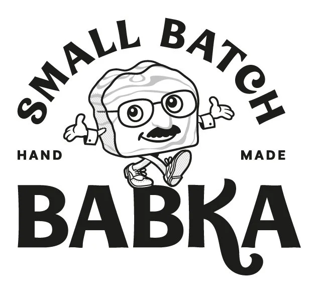 Logo of Small Batch Babka, featuring a cartoon baker character with glasses, arms outstretched, and the text 'Small Batch Babka' in bold letters.