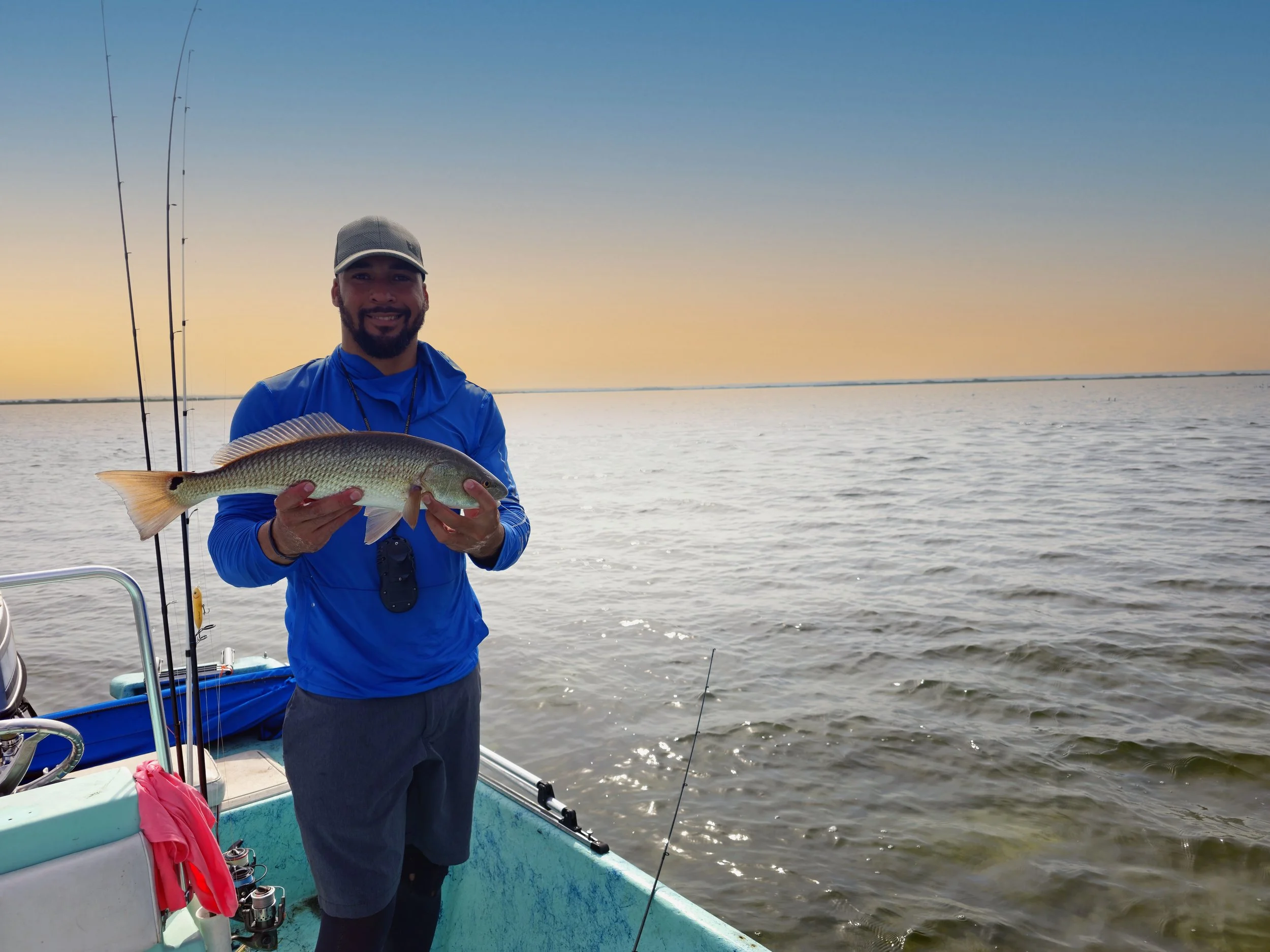 Person holding a redfish on a boat