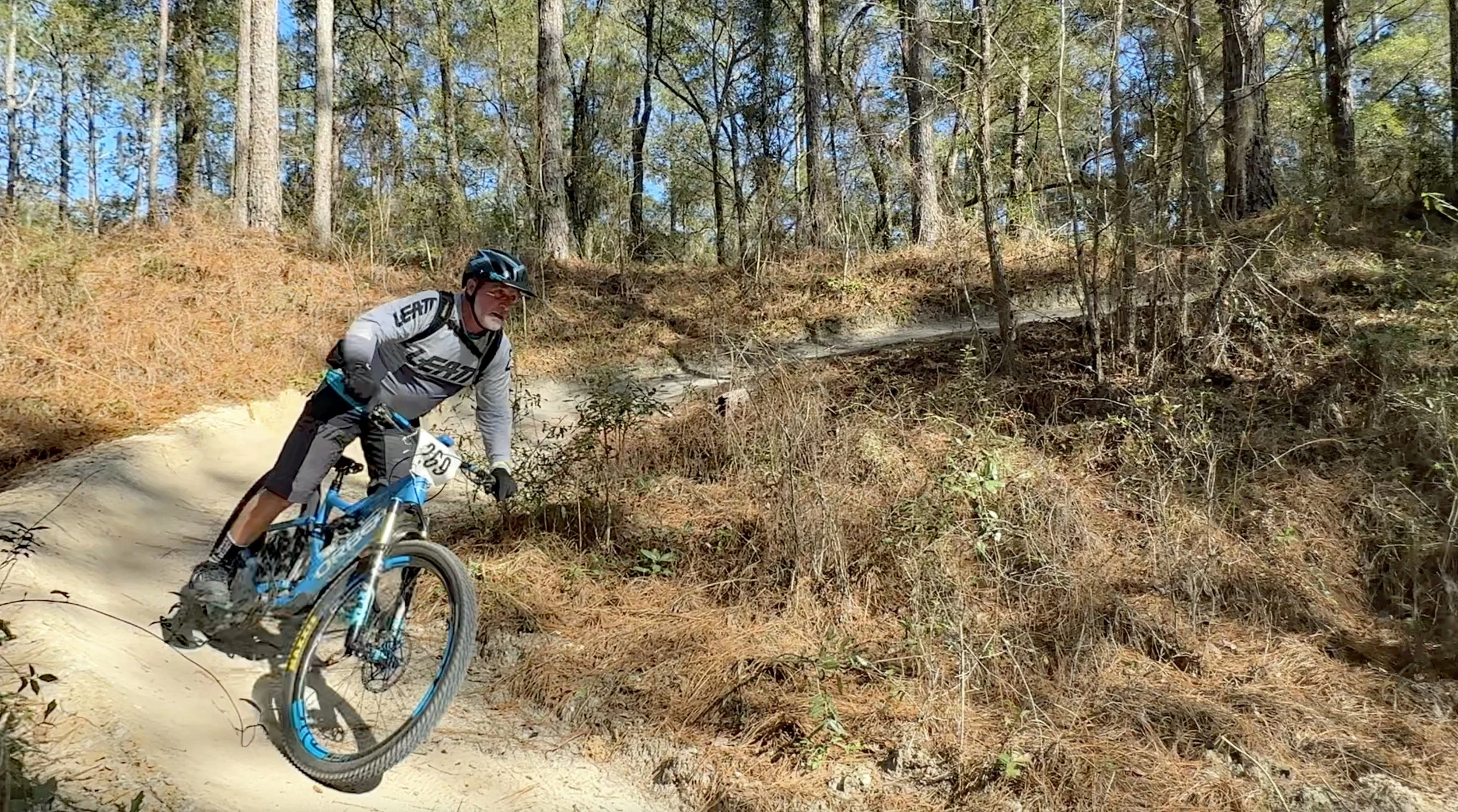 person riding mountain bike through trail