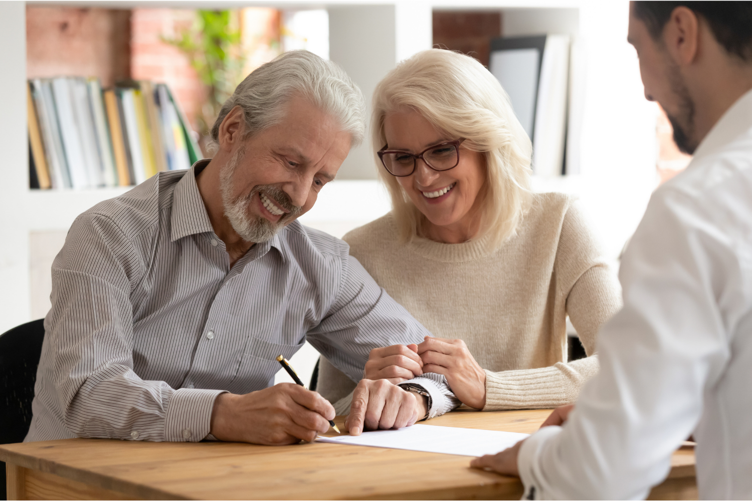 Couple completing Medicare enrollment paperwork with a Medicare professional.
