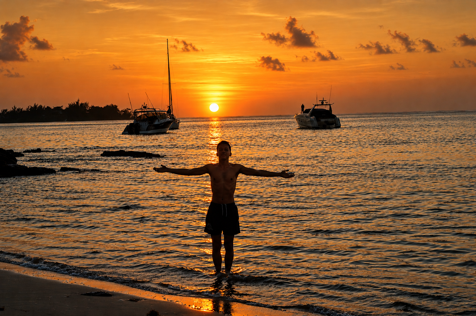 Un homme debout dans l'eau à la plage au coucher du soleil, avec deux bateaux en arrière-plan sur l'eau calme, un ciel orange avec quelques nuages.