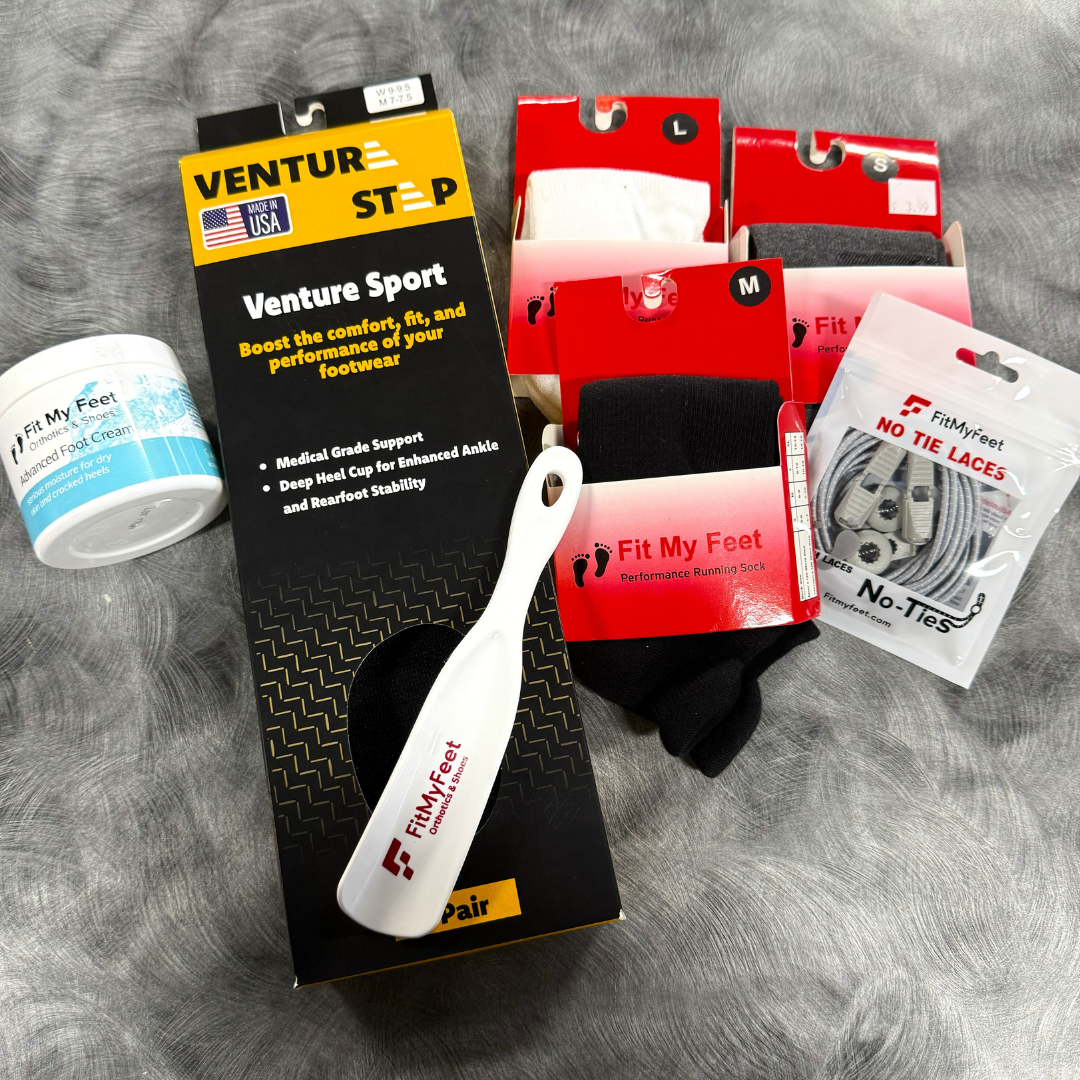 A collection of foot care and sock items, including a jar of foot cream, various pairs of socks in black, white, and gray, a pair of over-the-counter insoles, and no-tie laces, all arranged on a gray surface.