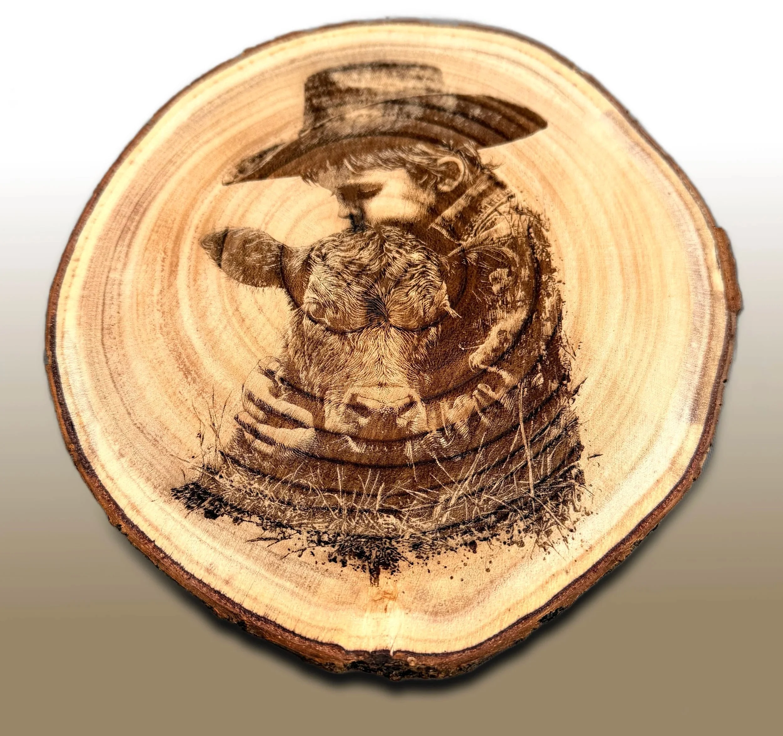 Wooden log cross-section with laser engraved image of a man wearing a hat and beard, holding a bird near his face.