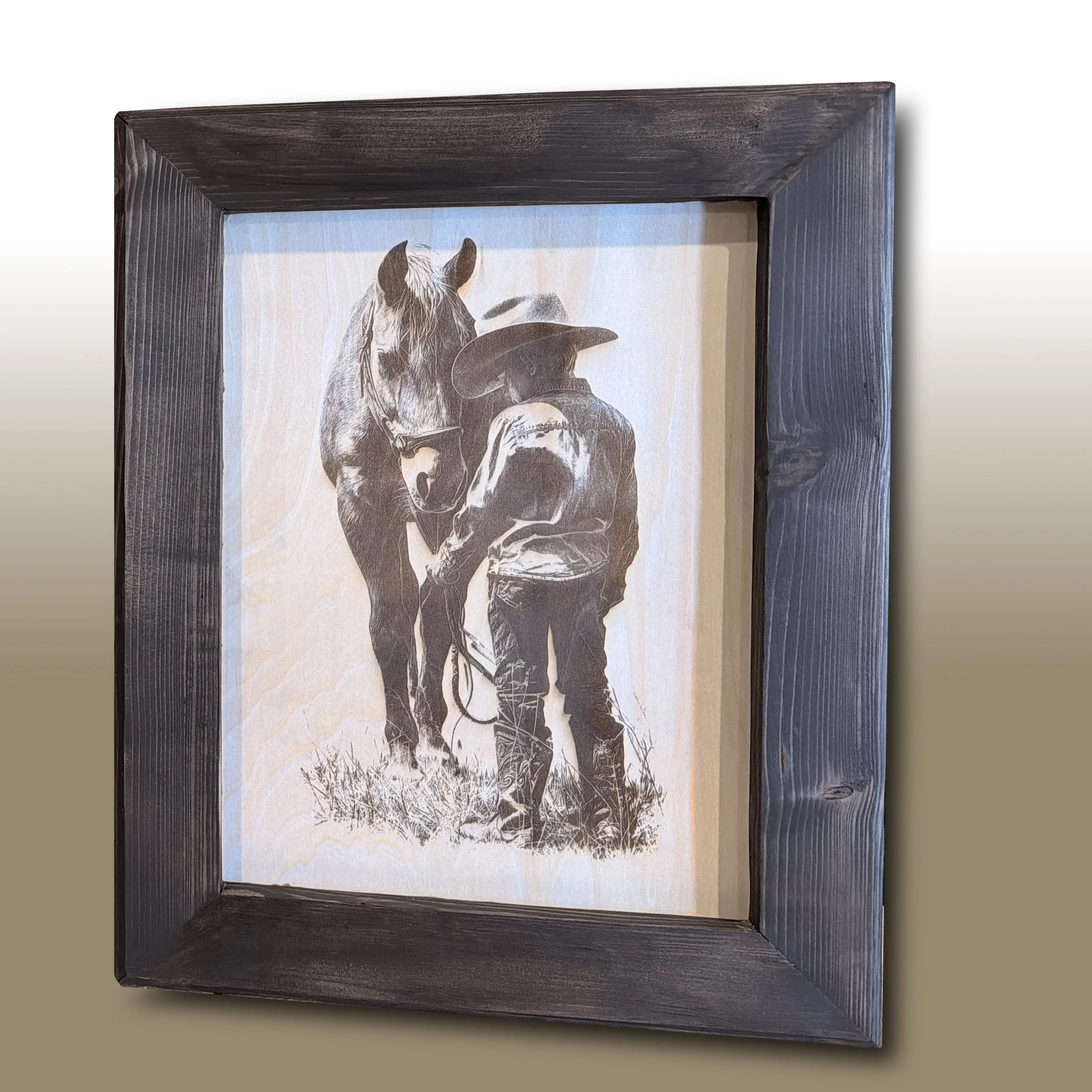 Framed monochrome painting of a cowboy and a horse.
