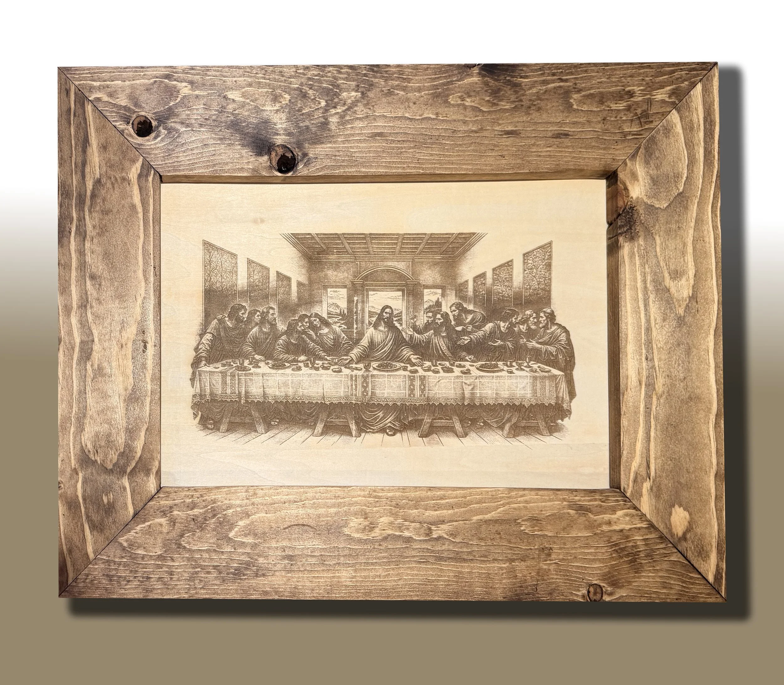An ornate framed image of Leonardo da Vinci's The Last Supper hanging on a wall with wooden molding.