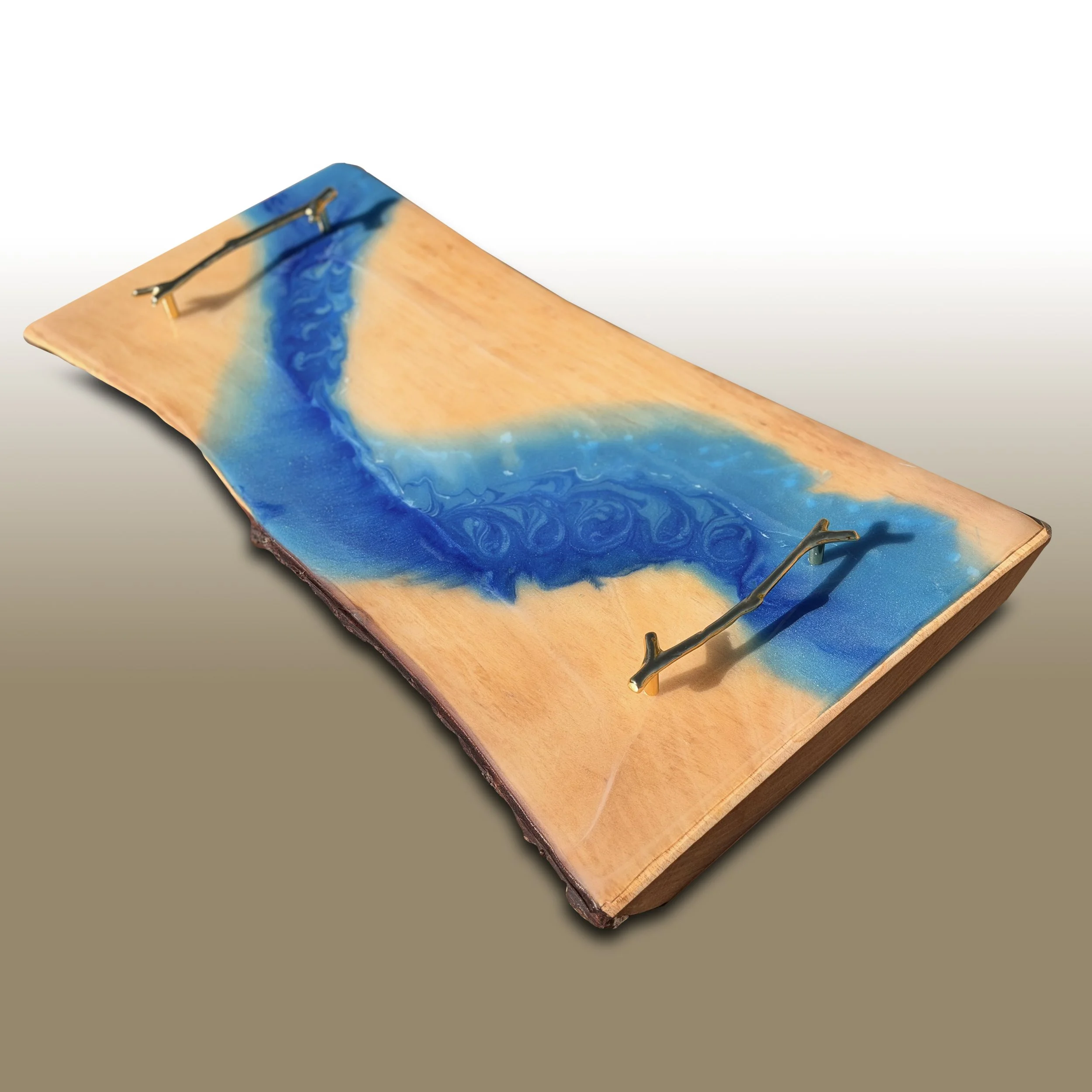 Close-up of a wooden board with a blue and orange resin river design, with a metal tool resting on it.