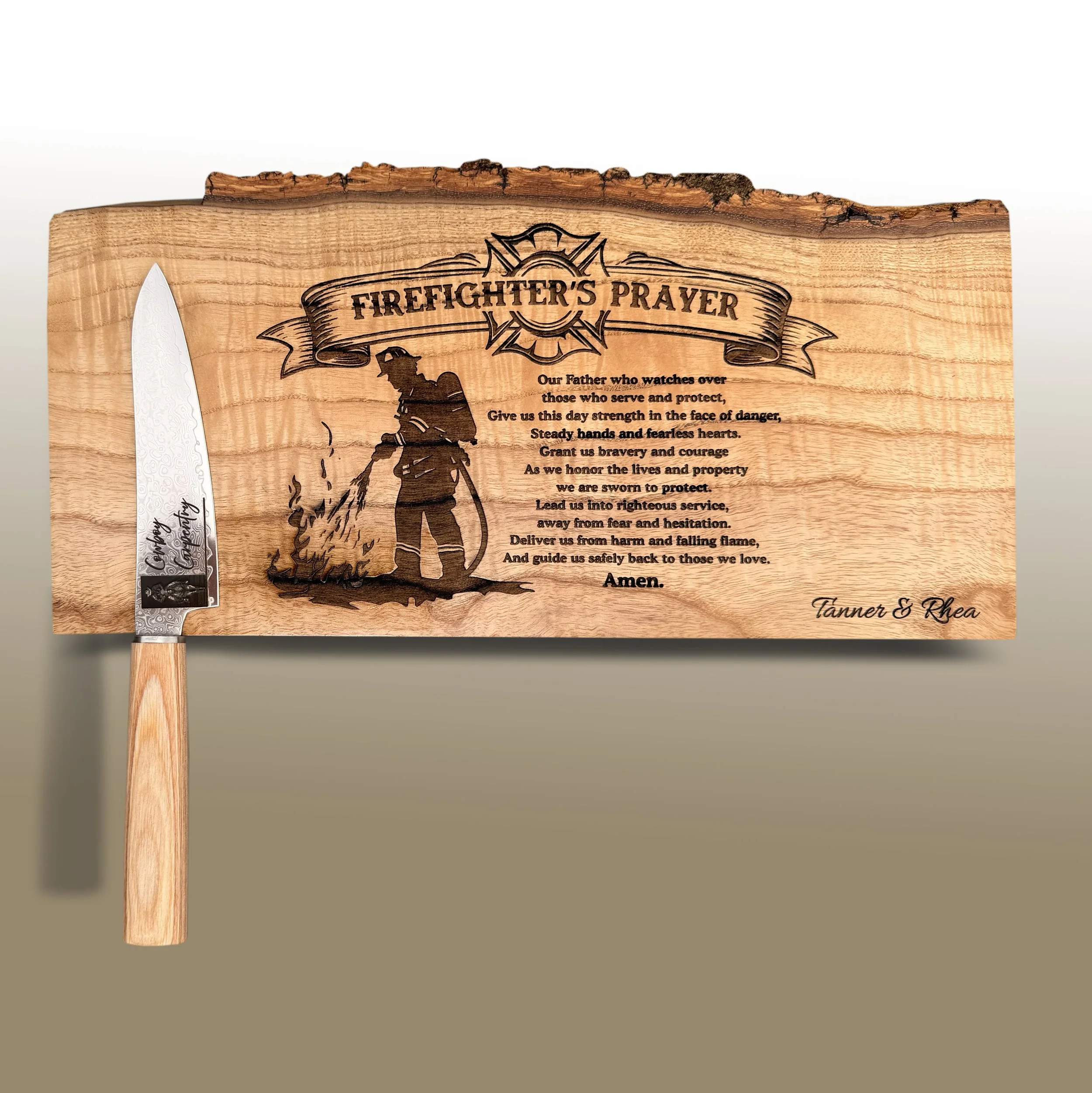 Wooden plaque with engraved text titled 'Firefighter's Prayer' featuring a silhouette of a firefighter with a hose and a fire truck, alongside a chef's knife with decorative etching on the blade.