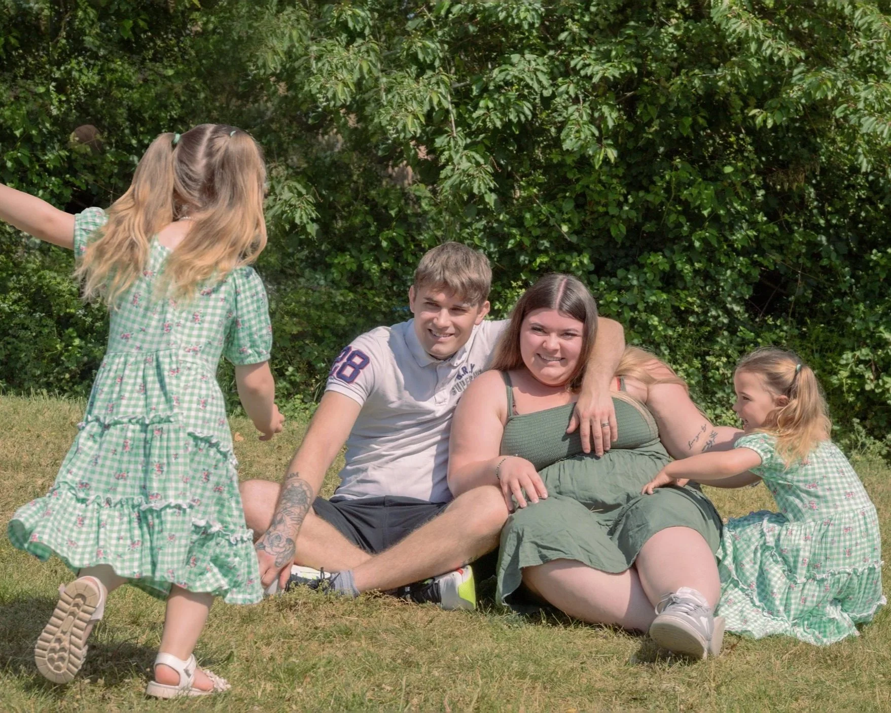 Family laughing together on the grass during an outdoor family photoshoot in Reading