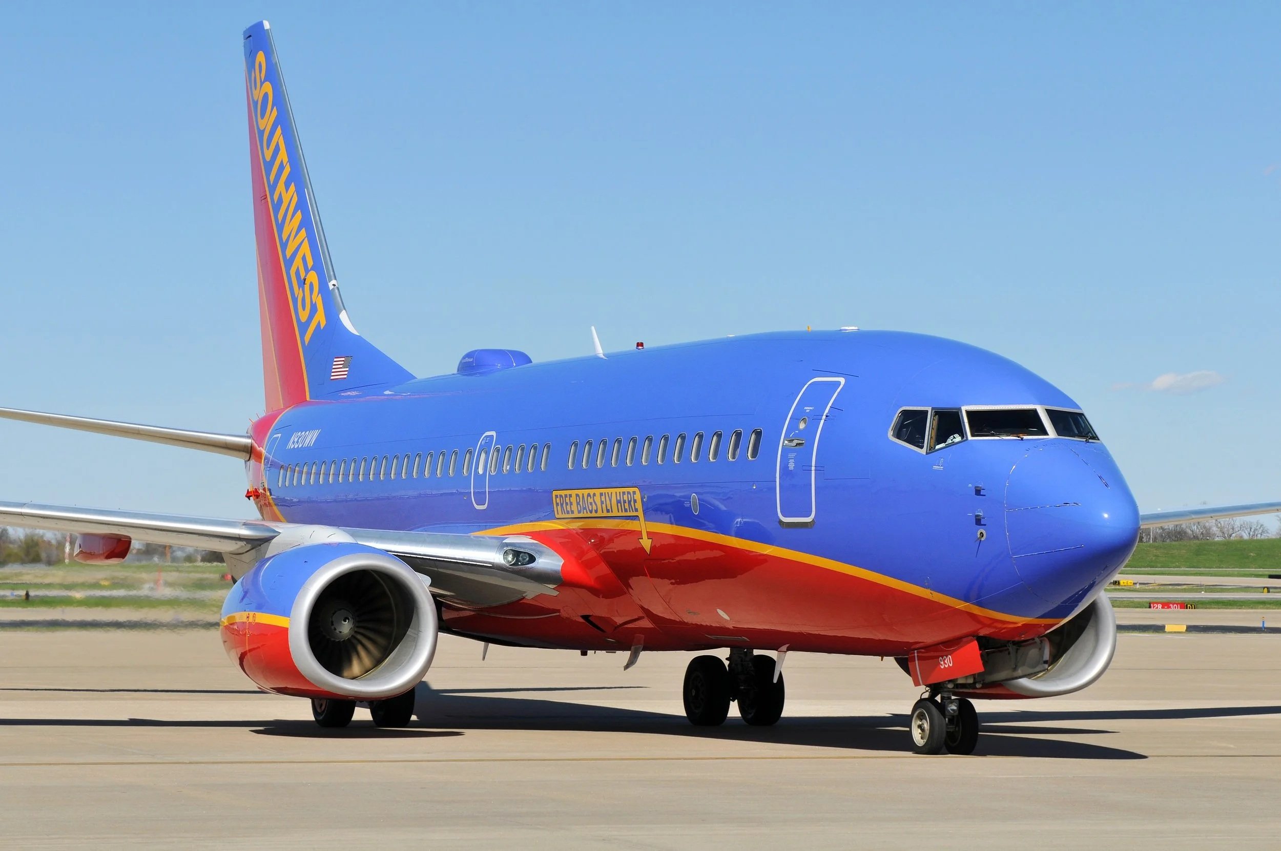 A Southwest Airlines airplane parked on the tarmac under a blue sky.