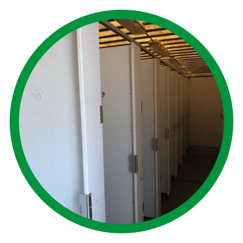 Rentable restroom stalls with closed doors in a row inside a building.