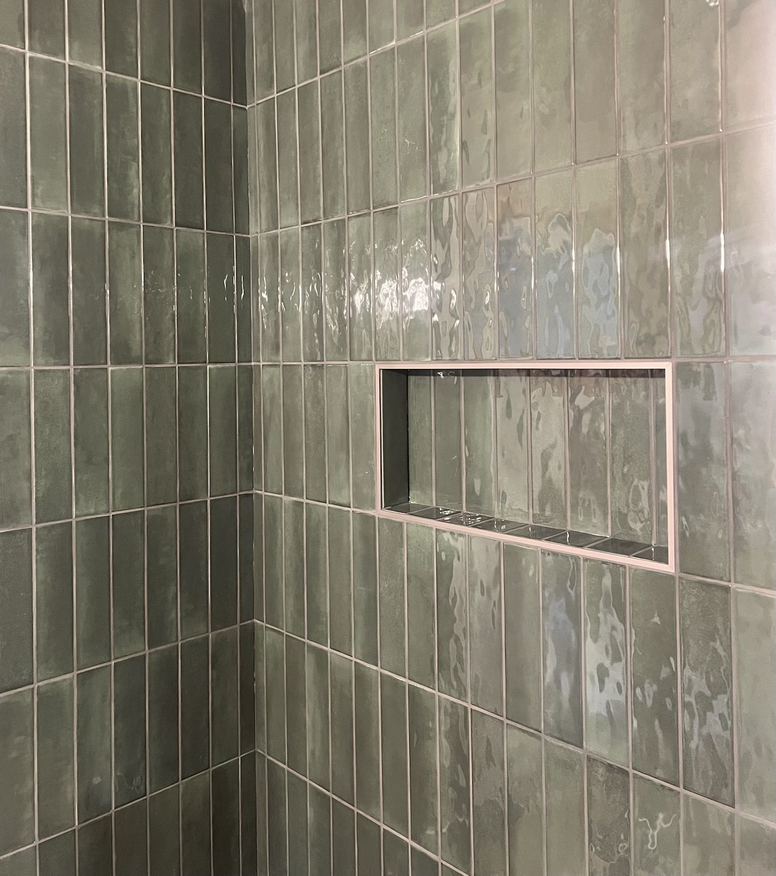 Green tiled bathroom shower with a recessed shampoo shelf. Iowa City. Stecker Home Services. Home Renovations. Iowa City Contractor. 