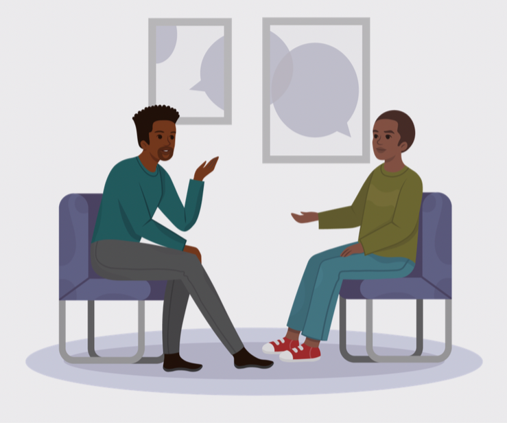Two people having a conversation in a therapy session, sitting on chairs in a room with abstract artwork on the wall.
