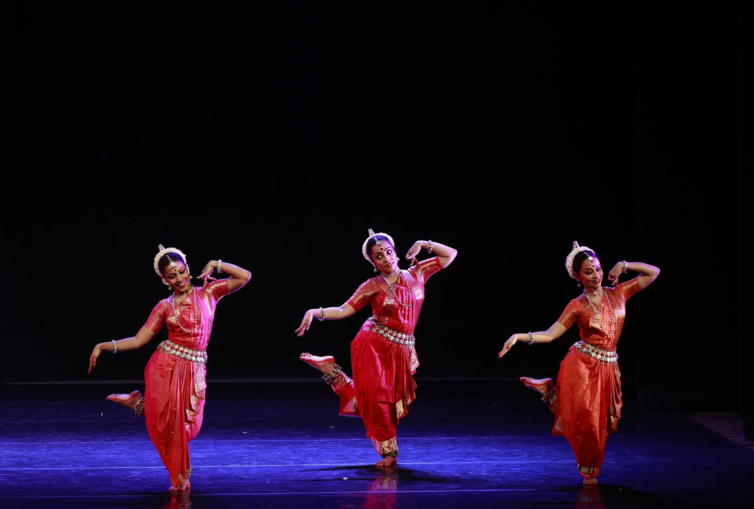 three dancers performing in front of a black backdrop