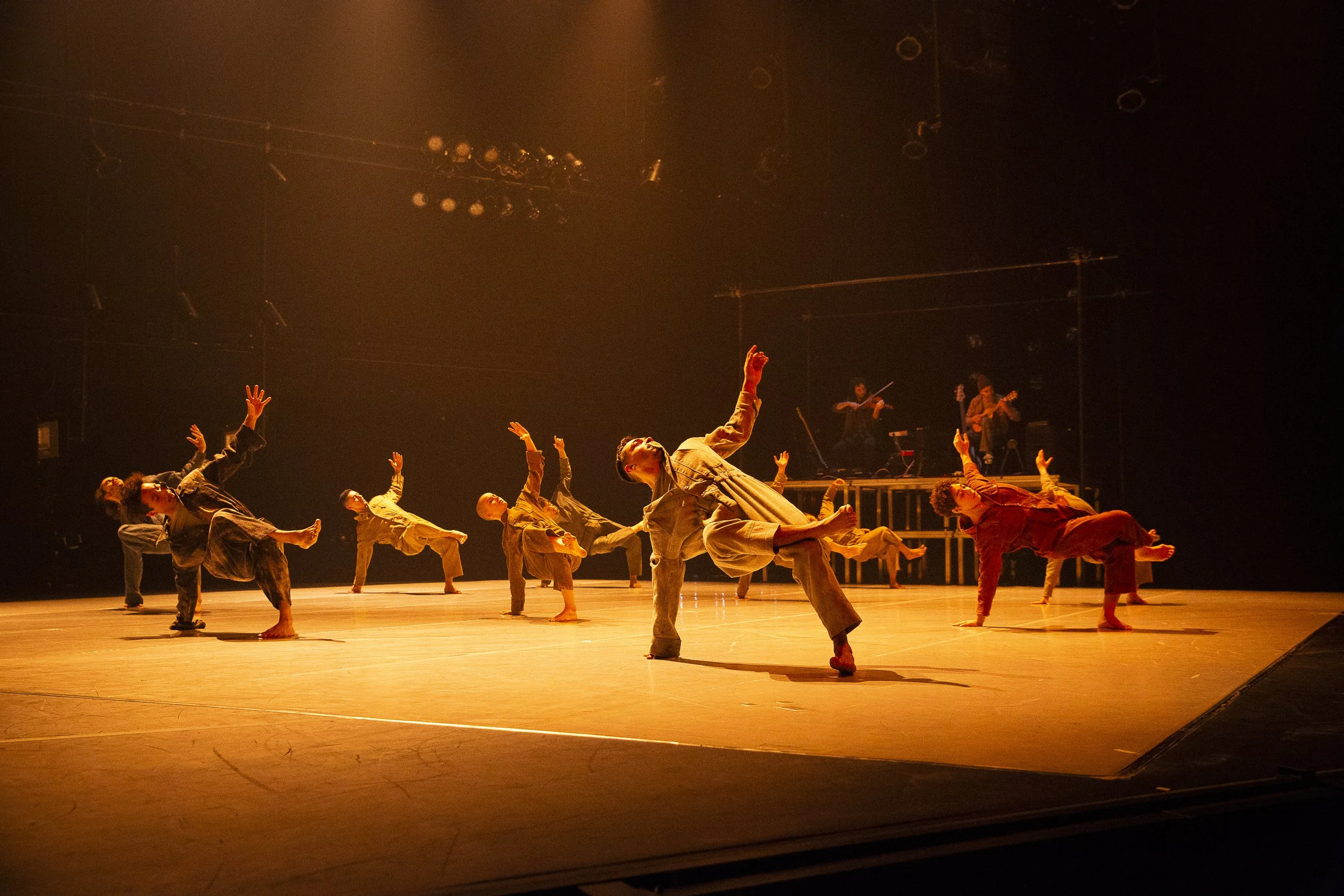 several dancers performing and bathed in a warm light