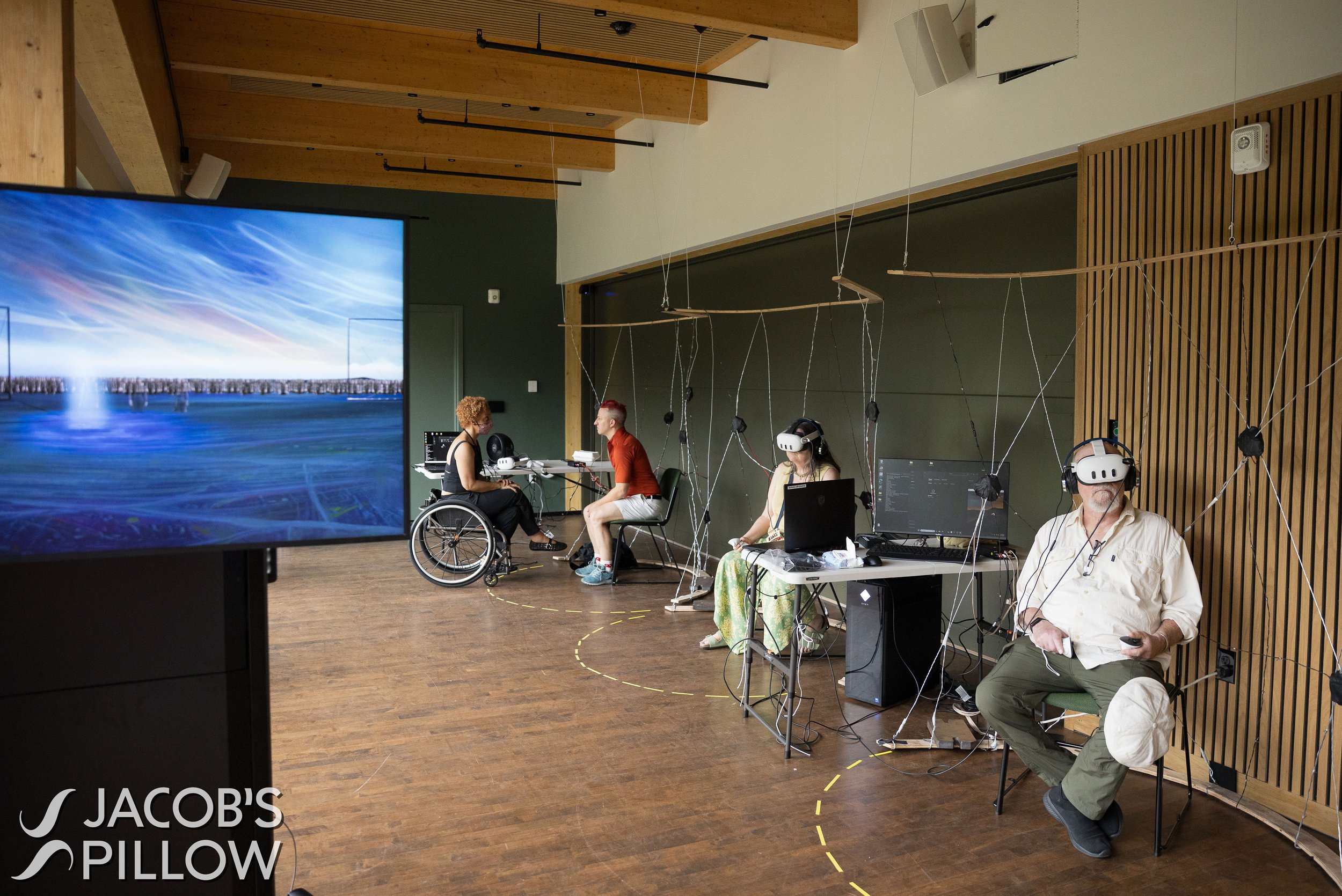 performers hooked up to virtual reality sets with a video backdrop