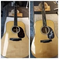 Two acoustic guitars, one with a darker pickguard and a white symbol, and the other with a black pickguard and white star symbol, placed side by side.