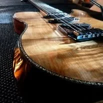 Close-up of an acoustic guitar's body showing wood grain and strings.