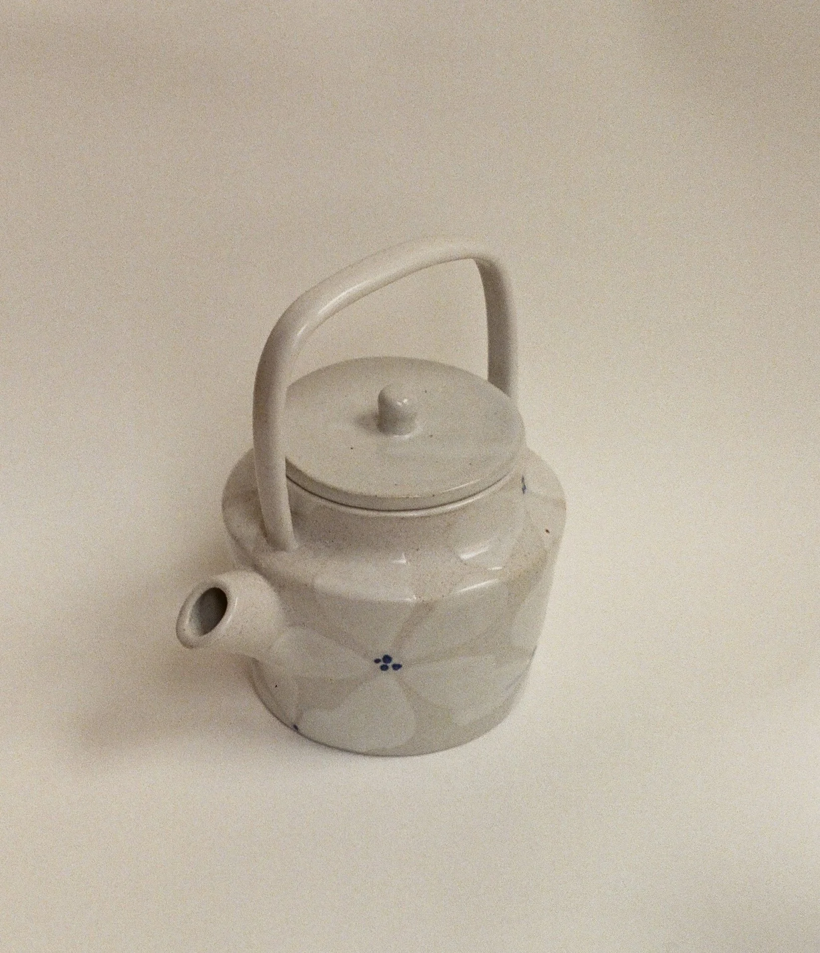A white electric kettle with a black floral pattern on a white surface.