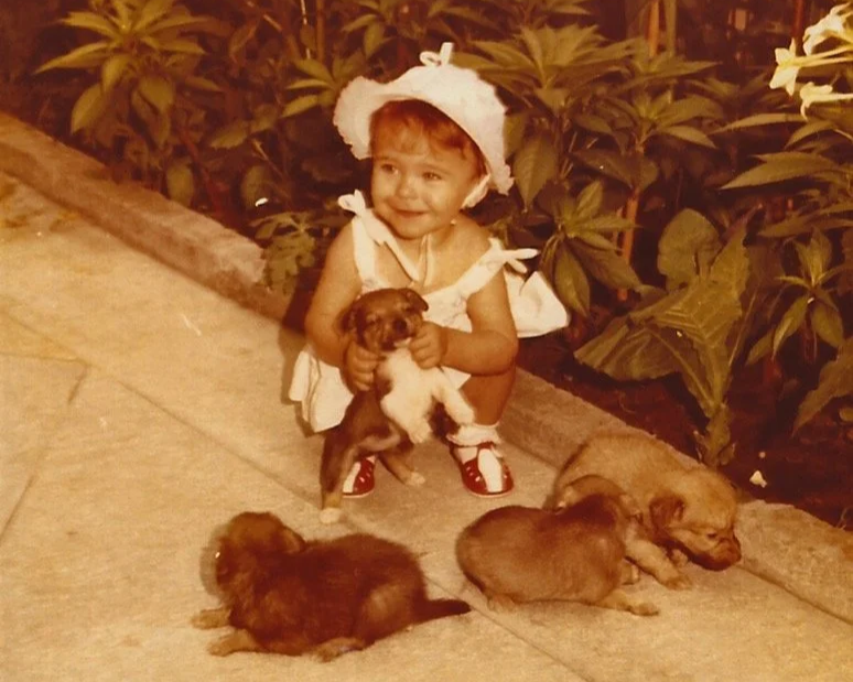Andra Mocanu covered in puppies as a baby—proof this was always her path