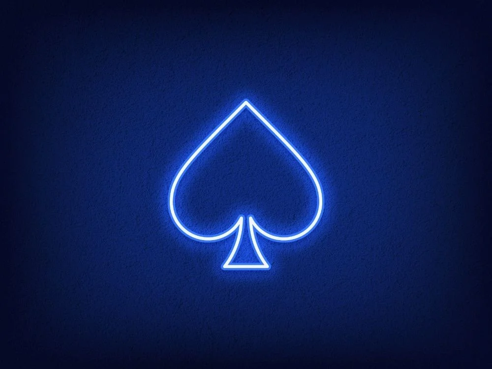 Blue neon light in the shape of a spade symbol on a dark wall.