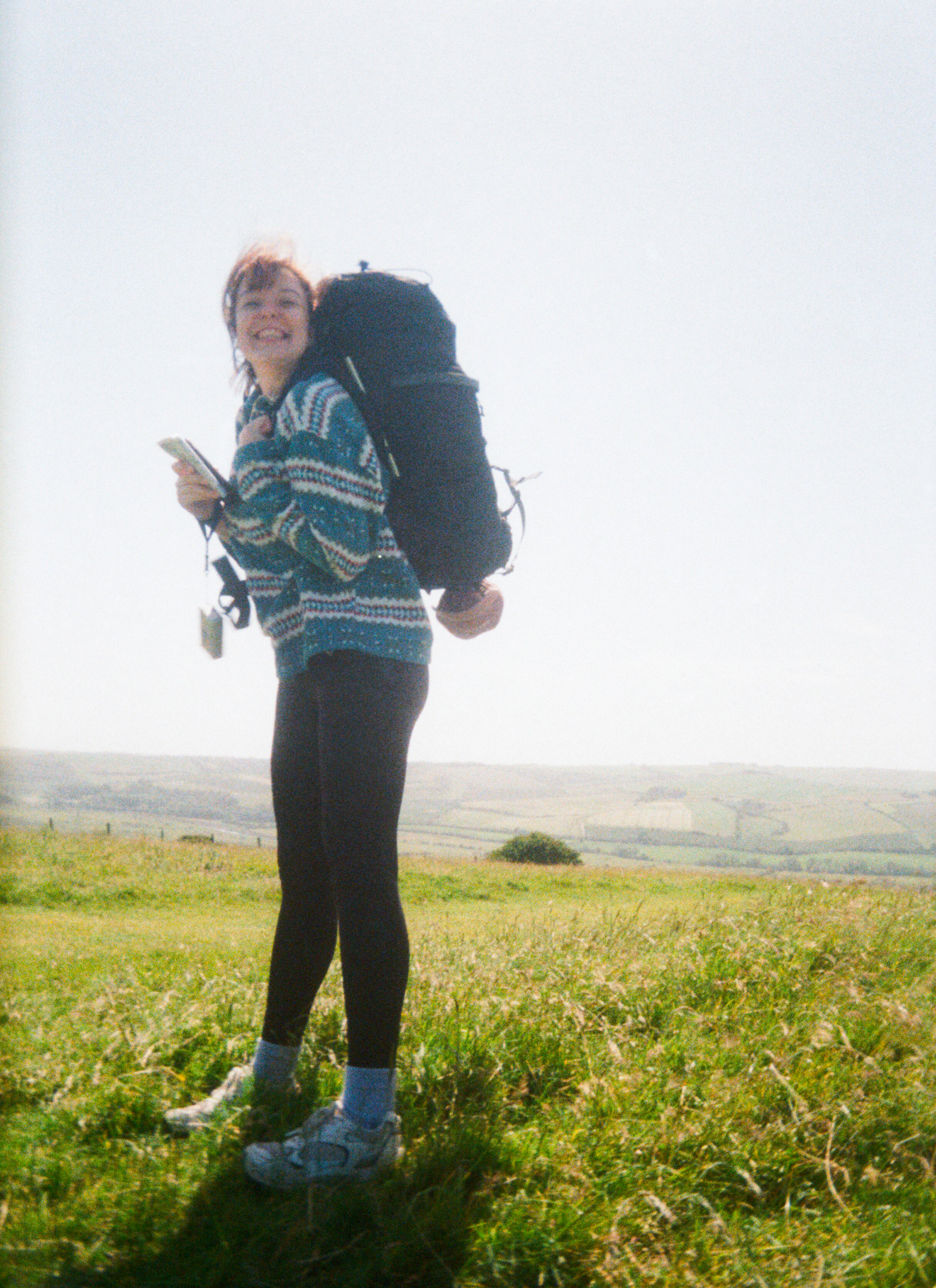 film photo of woman with hiking gear in a field