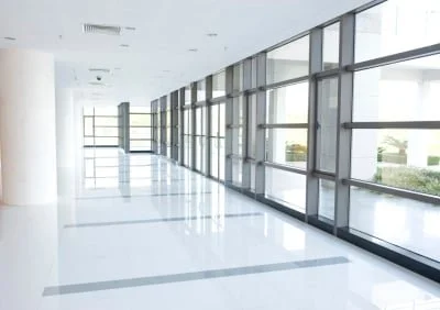 Empty modern hallway with large windows and white floors