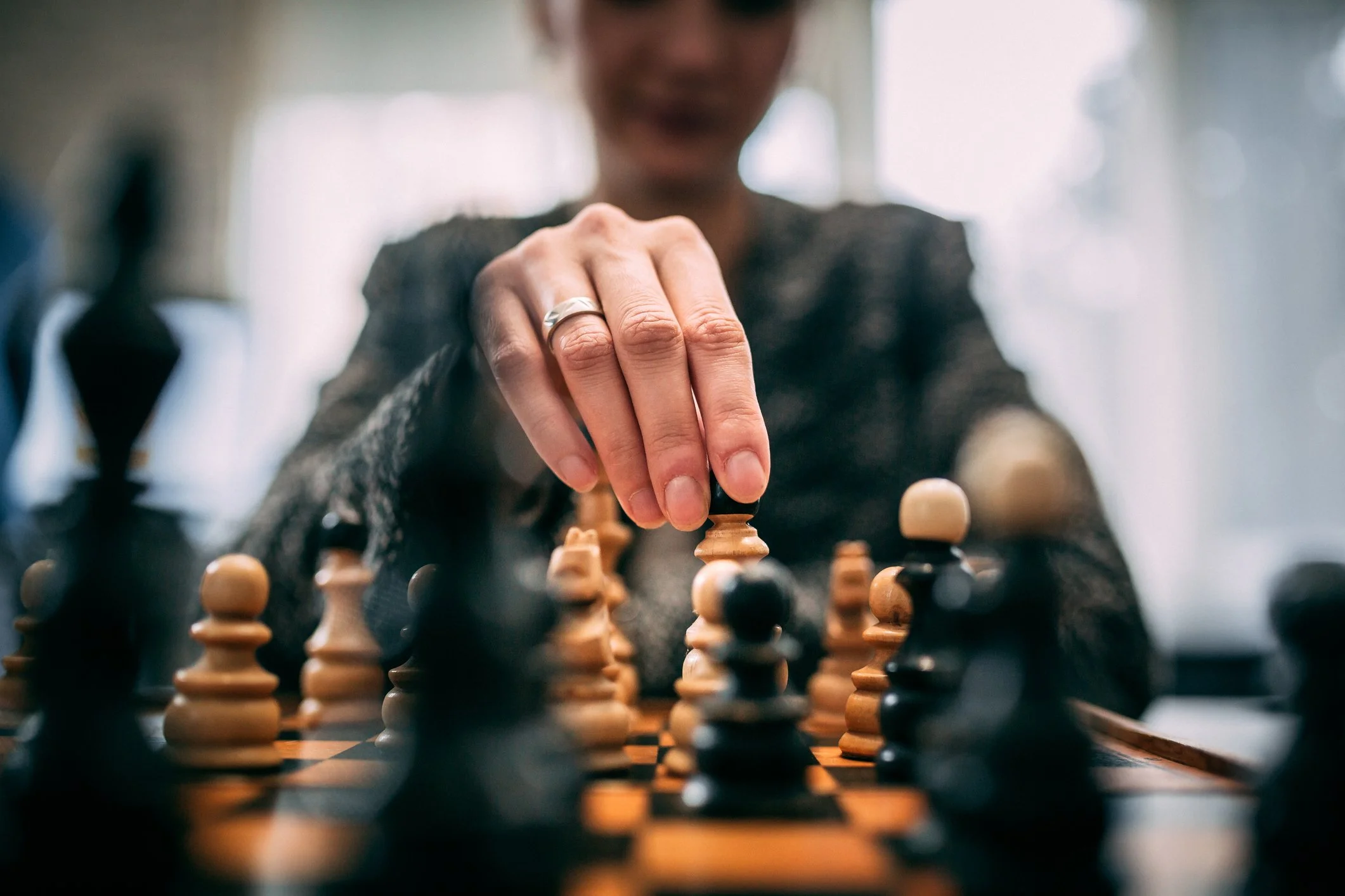 A chessboard with a hand moving a piece, representing planning and strategic decision-making.