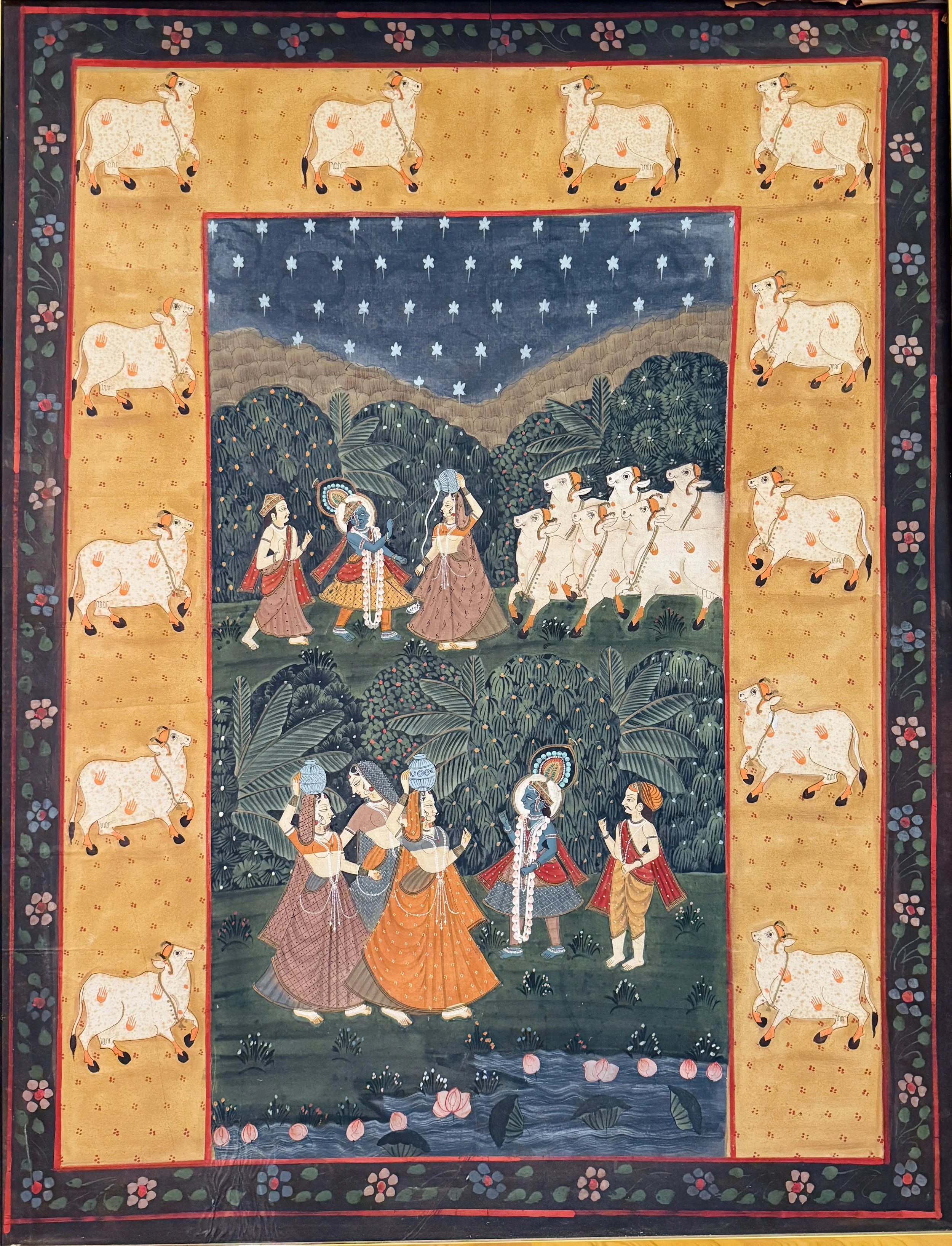 A traditional Indian miniature painting depicting a scene with women in colorful attire, surrounded by lush greenery, water, lotus flowers, and cow figures on an orange border.