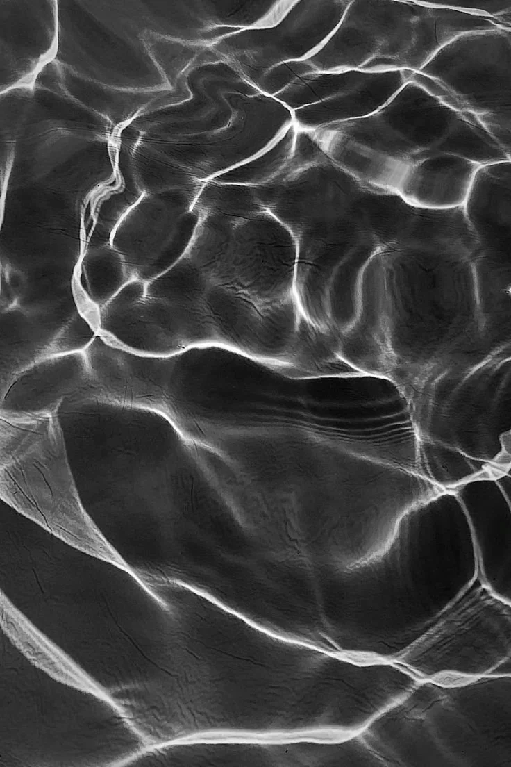 Close-up of water with light reflections creating intricate patterns on the surface.